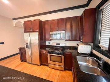 Chicago apartment for rent - a kitchen with wooden cabinets and stainless steel appliances