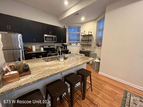 Chicago apartment for rent - A kitchen with granite countertops and black cabinets.