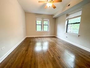 Chicago apartment for rent - A room with wooden floors and a ceiling fan.