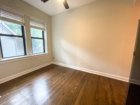 Chicago apartment for rent - A room with wooden flooring and a window with blinds.