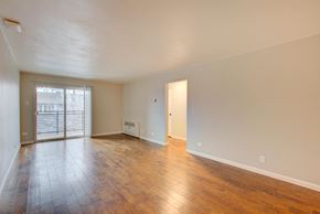 Denver apartment for rent - A room with wooden floors and white walls.