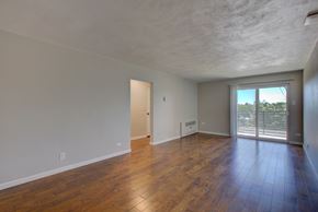 Denver apartment for rent - A room with wooden floors and a sliding glass door.
