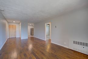 Denver apartment for rent - A room with wooden floors and white walls.