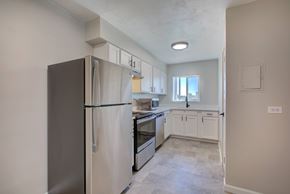 Denver apartment for rent - A kitchen with a refrigerator, oven, and cabinets.