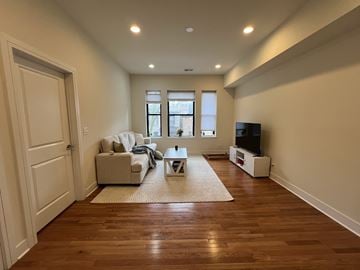 Chicago apartment for rent - A living room with a white couch and a wooden floor.