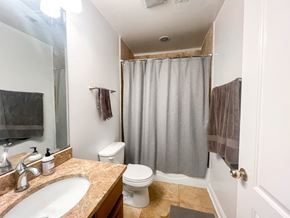 Chicago apartment for rent - A bathroom with a toilet, sink, and shower curtain.