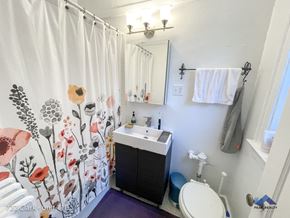 Evanston apartment for rent - a bathroom with a shower curtain and a sink and a toilet
