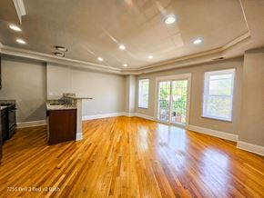 Chicago apartment for rent - an empty living room with hardwood floors and a kitchen
