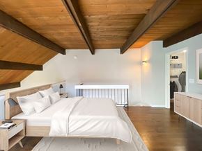 Chicago apartment for rent - A bedroom with a bed, nightstand, and a wooden ceiling.