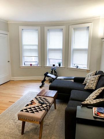 Evanston apartment for rent - a living room with a couch and a table and three windows