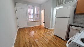 Chicago apartment for rent - A kitchen with a white fridge and wooden floors.