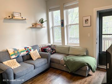 Chicago apartment for rent - A living room with a grey couch and a green blanket on it.