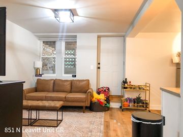 Chicago apartment for rent - A living room with a brown couch and a black trash can.