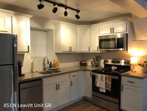 Chicago apartment for rent - A kitchen with a black stove top oven and a black microwave above the stove.