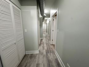 Chicago apartment for rent - A long hallway with a carpeted floor and white walls.