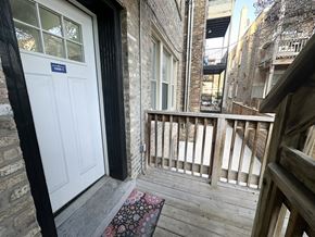 Chicago apartment for rent - A balcony with a white door and a rug on the floor.