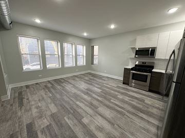 Chicago apartment for rent - A spacious kitchen with a grey floor and stainless steel appliances.