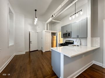 Chicago apartment for rent - A kitchen with a white counter top and wooden floors.