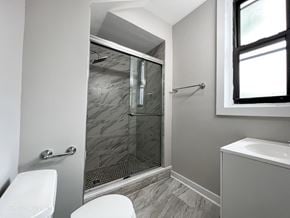 Chicago apartment for rent - A bathroom with a toilet, sink, and walk-in shower.