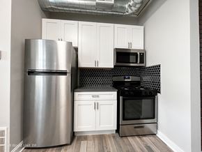 Chicago apartment for rent - A kitchen with a stainless steel refrigerator, microwave, and oven.