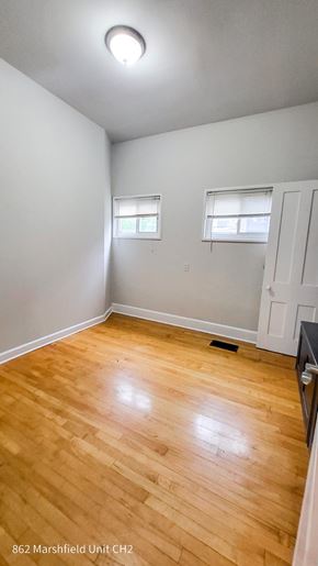 Chicago apartment for rent - A room with wooden flooring and two windows.