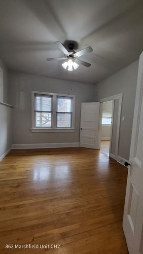 Chicago apartment for rent - A room with a ceiling fan and a window.