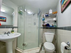 Chicago apartment for rent - A white toilet is in a small bathroom with a sink and a shower.