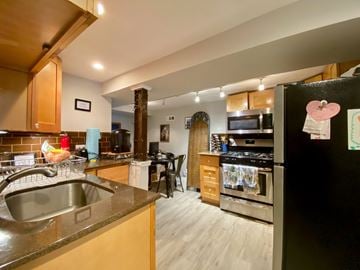 Chicago apartment for rent - A kitchen with a black fridge and a stove top oven.