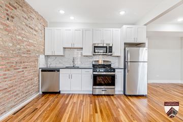 Chicago apartment for rent - A kitchen with white cabinets and a brick wall.