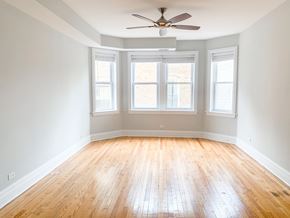 Chicago apartment for rent - A room with a ceiling fan and three windows.