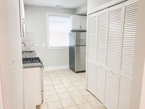 Chicago apartment for rent - A kitchen with a refrigerator and a stove top oven.
