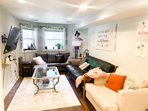 Chicago apartment for rent - A living room with a white couch, a glass coffee table, and a television.