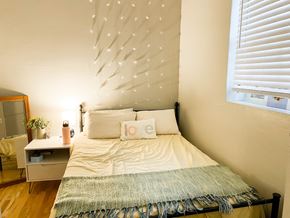 Chicago apartment for rent - A bedroom with a bed, nightstand, and a wall decoration.