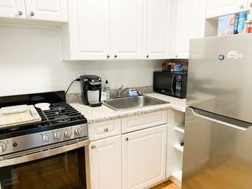 Chicago apartment for rent - A kitchen with white cabinets and a stainless steel refrigerator.
