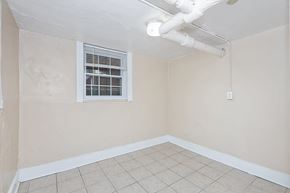 Denver apartment for rent - A room with a window and a white pipe on the ceiling.