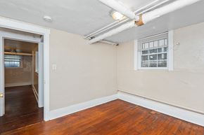 Denver apartment for rent - A room with a wooden floor and a window with blinds.