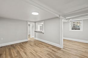 Denver apartment for rent - A room with wooden floors and white walls.