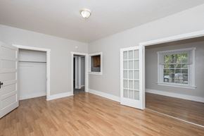 Denver apartment for rent - A room with a white door, a window with white frames, and a wooden floor.