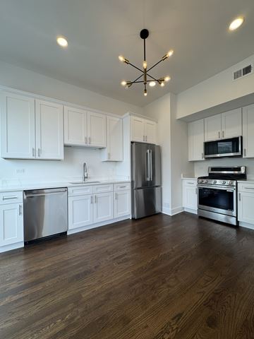 Chicago apartment for rent - A kitchen with white cabinets and stainless steel appliances.