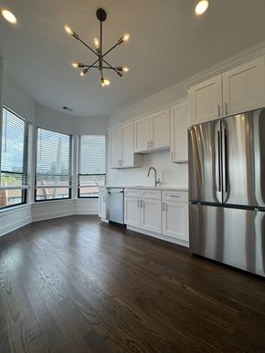 Chicago apartment for rent - A kitchen with a stainless steel refrigerator and wooden flooring.