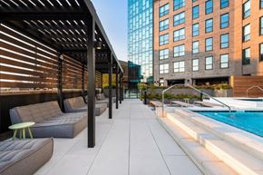 Chicago apartment for rent - A modern outdoor seating area with a pool and a building in the background.