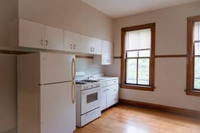 Chicago apartment for rent - A white kitchen with a refrigerator, stove, and cabinets.