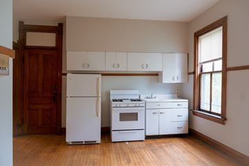 Chicago apartment for rent - A kitchen with white appliances and wooden floors.