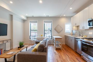 Chicago apartment for rent - A modern living room with a grey couch and a wooden coffee table.