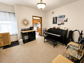 Chicago apartment for rent - A room with a piano, a drum set, and a guitar.