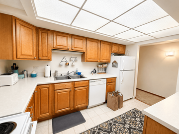 Chicago apartment for rent - A kitchen with wooden cabinets and white appliances.