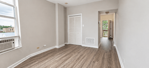 Chicago apartment for rent - A room with a window and a door leading to another room.
