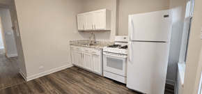 Chicago apartment for rent - A white kitchen with a white fridge and white cabinets.