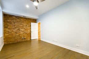Chicago apartment for rent - A room with a brick wall and wooden floor.
