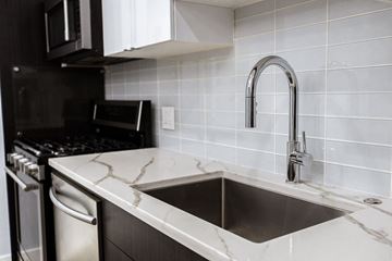 Chicago apartment for rent - A kitchen with a sink and a black oven.